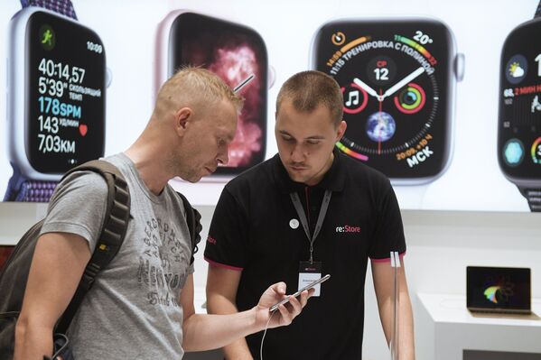 Мужчина рассматривает телефон iPhone XS Max в магазине re:Store торгово-развлекательного центра «Галерея» в Санкт-Петербурге