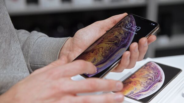 Посетитель рассматривает телефон iPhone XS Max в магазине re:Store в Санкт-Петербурге