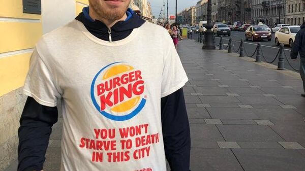 Промоутер компании Burger King в рекламной футболке с надписью В этом городе вы не умрете от голода на улице в Санкт-Петербурге