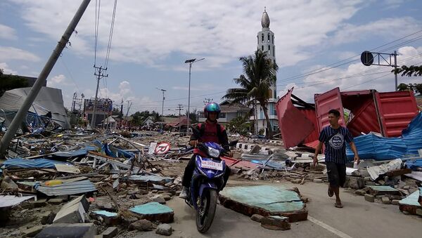 Жители пробираются по улице, полной мусора, после землетрясения и цунами в городе Палу на острове Сулавеси, Индонезия. 29 сентября 2018