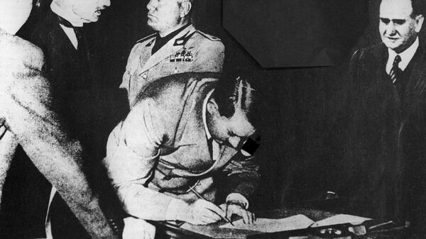 Рейхсканцлер Германии Адольф Гитлер подписывает Мюнхенское соглашение 1938 года о разделе Чехословакии
