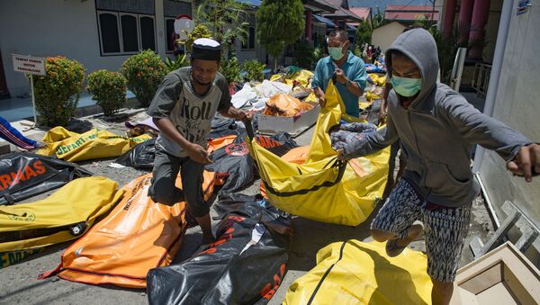 Члены семьи уносят тело родственника из полицейского госпиталя в Палу на острове Сулавеси, где произошло сильное землетрясение, Индонезия. 30 сентября 2018