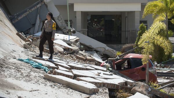 Полицейский на развалинах десятиэтажного отеля в Палу на острове Сулавеси, после того как он рухнул в результате сильного землетрясения, Индонезия. 30 сентября 2018