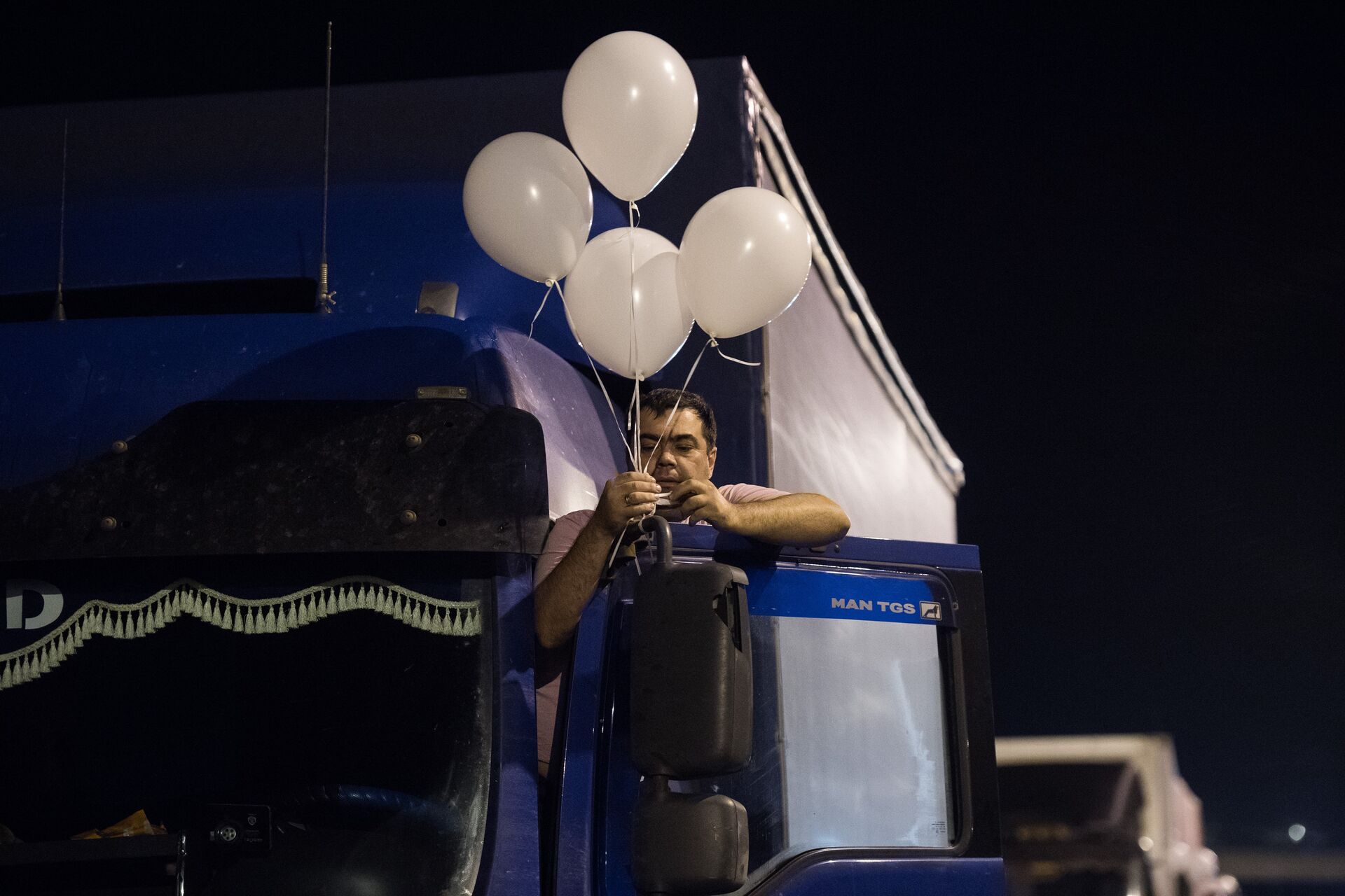 Водитель грузовой машины, украшает шариками кабину перед первым проездом по Крымскому мосту - РИА Новости, 1920, 12.07.2022