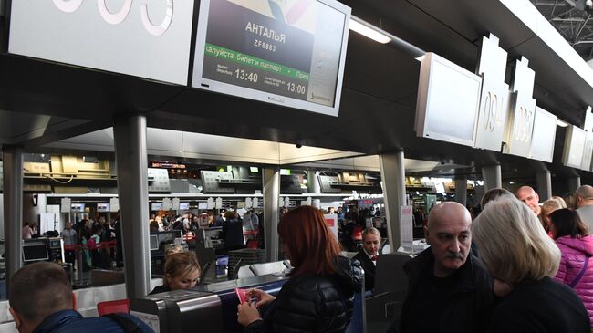 Пассажиры авиакомпании AZUR air у стойки регистрации в аэропорту Внуково
