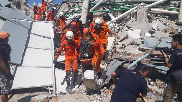 Сотрудники Humas Basarnas на месте рухнувшего отеля в Палу на острове Сулавеси, Индонезия. 30 сентября 2018 года
