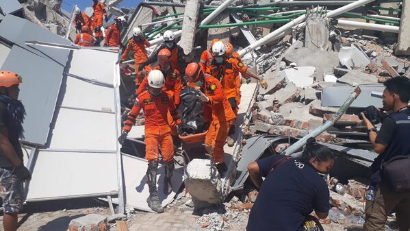 Сотрудники Humas Basarnas на месте рухнувшего отеля в Палу на острове Сулавеси, Индонезия. 30 сентября 2018 года