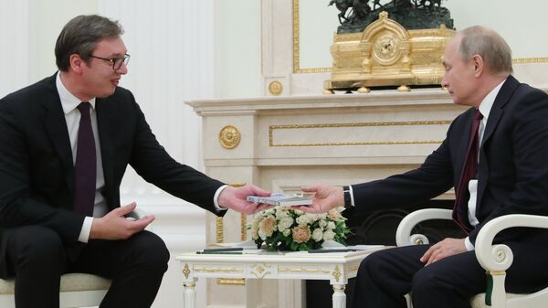 Президент Сербии Александр Вучич вручает президенту РФ Владимиру Путину книгу Моя прекрасная Сербия во время встречи в Москве
