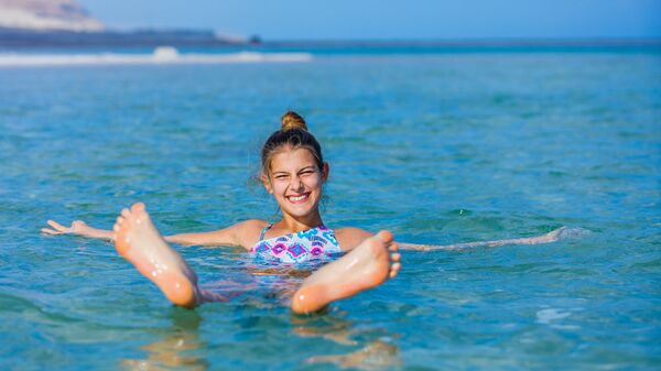 Девушка плавает в Мертвом море, Израиль