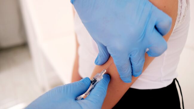 Медик делает прививку от гриппа