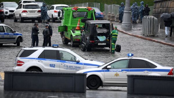 Сотрудники полиции эвакуируют автомобиль Мерседес на Васильевском спуске в Москве
