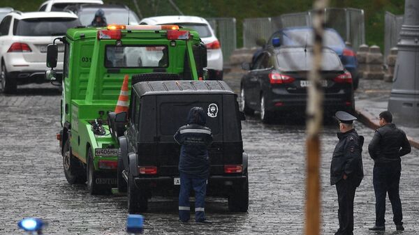 Сотрудники полиции эвакуируют автомобиль Мерседес на Васильевском спуске в Москве