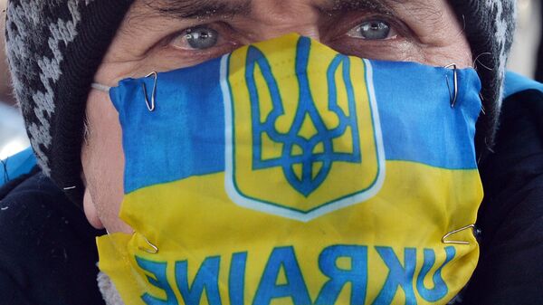 Участник акции протеста в маске с изображением флага и герба Украины в Киеве. Архивное фото