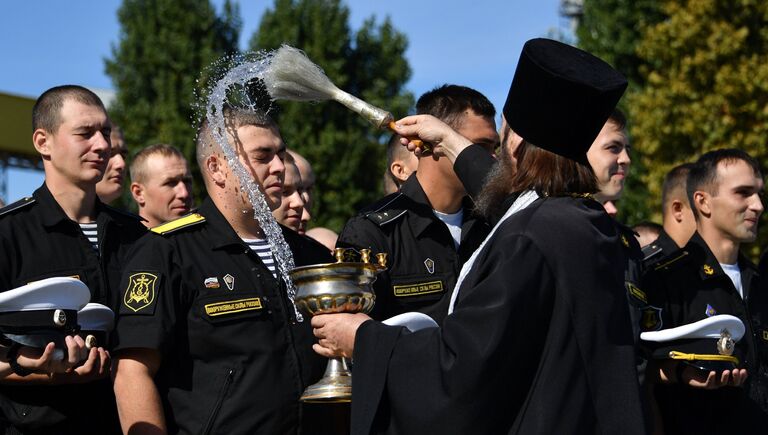 Священник окропляет святой водой экипаж фрегата Черноморского флота Адмирал Макаров, прибывший в Севастополь после выполнения задач в Средиземном море