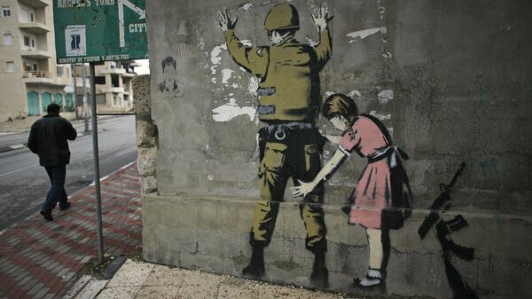 Граффити британского художника Бэнкси на стене в городе Вифлееме на Западном берегу реки Иордан