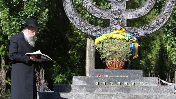 Раввин читает молитву у памятника Менора во время траурных мероприятий в память о трагедии Бабьего Яра в Киеве