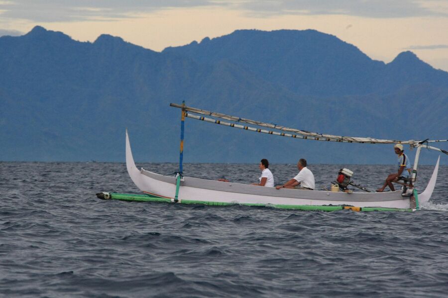 Туристы катаются на лодке у побережья острова Бали
