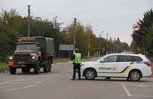 Сотрудники полиции Украины останавливают автомобили на дороге в Черниговской области после взрыва на военном складе. 9 октября 2018 Сотрудники полиции Украины останавливают автомобили на дороге в Черниговской области после взрыва на военном складе. 9 октября 2018