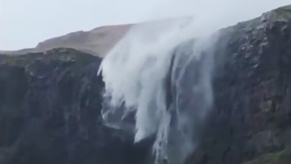Кадр из видео, на котором ветер останавливает водопад во время шторма на пляже Талискер