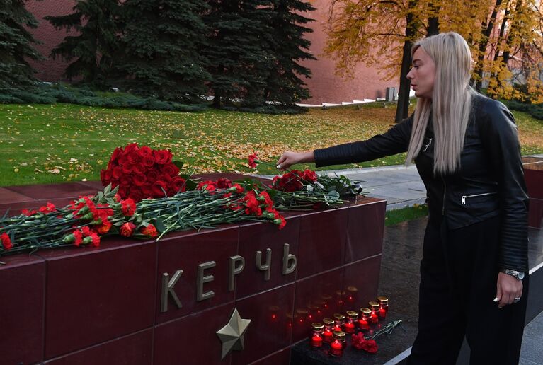 Девушка возлагает цветы на памятник городу-герою Керчи в Александровском саду в Москве в знак траура по погибшим при взрыве в колледже в Керчи