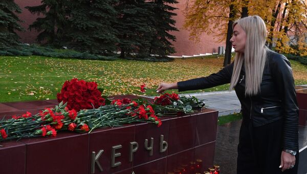 Девушка возлагает цветы на памятник городу-герою Керчи в Александровском саду в Москве в знак траура по погибшим при взрыве в колледже в Керчи