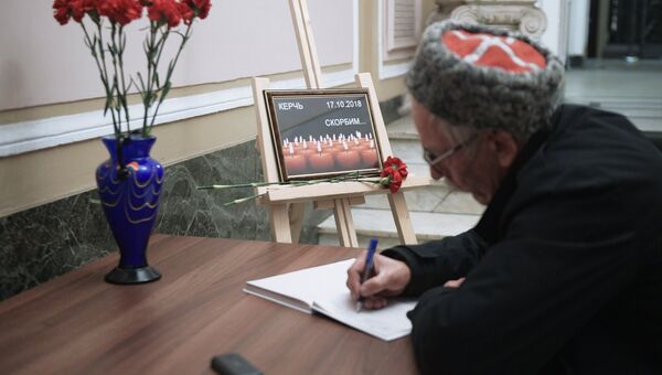 Мужчина оставляет запись в книге соболезнований в Санкт-Петербургском Доме национальностей в связи с происшествием в Керченском политехническом колледже