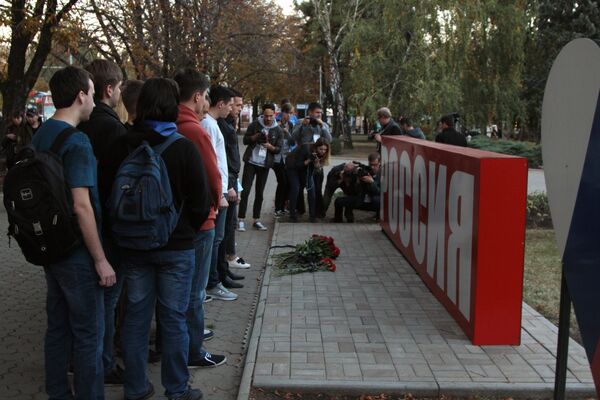 Цветы возле стелы Россия в сквере Первомайский в Донецке в знак траура по погибшим при взрыве в колледже в Керчи