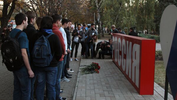 Цветы возле стелы Россия в сквере Первомайский в Донецке в знак траура по погибшим при взрыве в колледже в Керчи