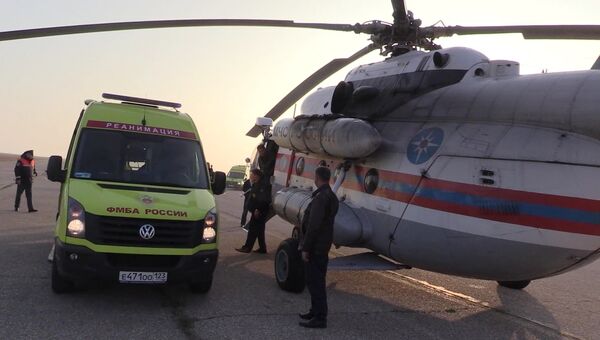 Карета скорой помощи с пострадавшими при нападении на Керченский политехнический колледж у вертолета Ми-8 МЧС России, который транспортирует пострадавших в Симферополь