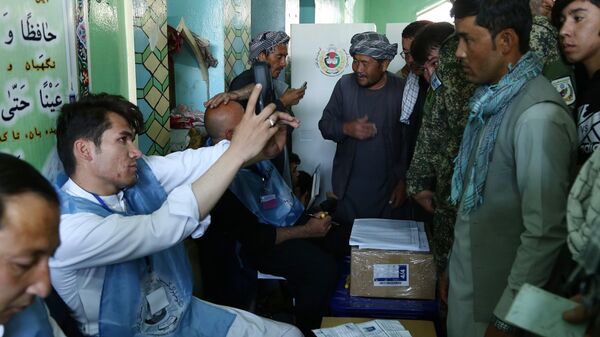 Мужчины во время регистрации перед голосованием на одном из избирательных участков Кабула. 20 октября 2018