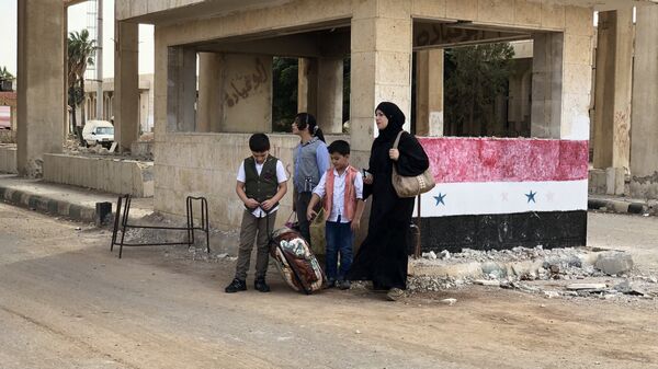 Женщина с детьми в современной части города Босра сирийской провинции Дераа в районе пограничного перехода Насиб на границе с Иорданией