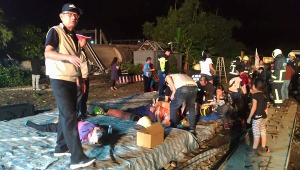 Спасатели оказывают помощь пострадавшим при сходе с рельсов скоростного поезда Puyuma Express на севере Тайваня. 21 октября 2018