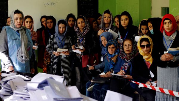 Наблюдатели следят за подсчетом голосов на парламентских выборых на одном из избирательных участков в Кабуде, Афганистан. 21 октября 2018