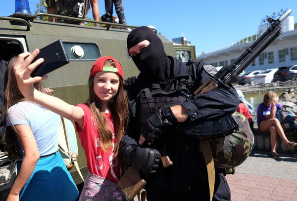 Девочка фотографируется с сотрудником полиции во время акции Курорт – 2015. Кубань – территория безопасности в Краснодарском крае