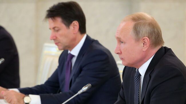 Президент РФ Владимир Путин и премьер-министр Италии Джузеппе Конте во время встречи с представителями итальянских деловых кругов в Кремле. 24 октября 2018