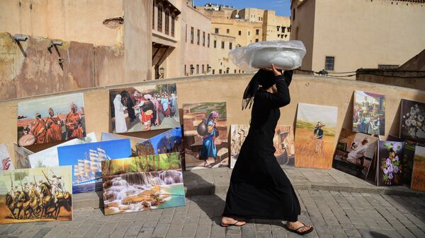 Женщина идет по мосту в городе Фес, Марокко