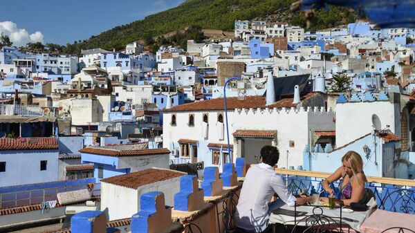 Люди в кафе на крыше одного из домов в городе Шифшавен, Марокко