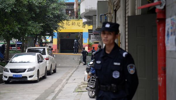 Полицейские у ворот детского сада, где женщина, вооруженная кухонным ножом, напала на детей, в Чунцине, Китай. 26 октября 2018