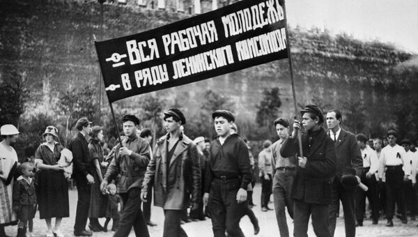 Колонна комсомольцев с лозунгом Вся рабочая молодежь - в ряды Ленинского комсомола во время демонстрации на Красной площади