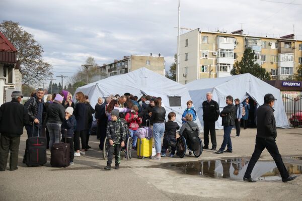 Пассажиры у полевого лагеря, развернутого добровольцами для организации питания пассажиров поездов, задержанных в Краснодарском крае из-за наводнения Пассажиры у полевого лагеря, развернутого добровольцами для организации питания пассажиров поездов, задержанных в Краснодарском крае из-за наводнения