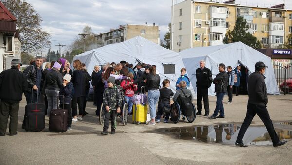 Пассажиры у полевого лагеря, развернутого добровольцами для организации питания пассажиров поездов, задержанных в Краснодарском крае из-за наводнения