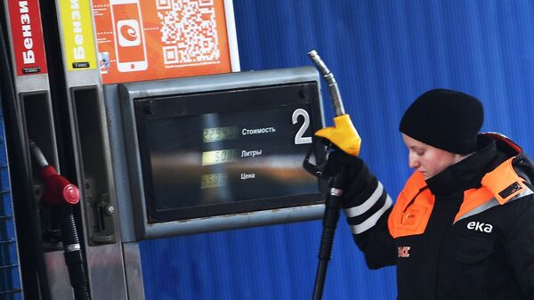 Рабочая у заправочной колонки на автозаправочной станции в Москве