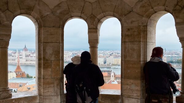 Туристы фотографируют город из конической шатровой башни на территории Рыбацкого бастиона на Крепостном холме в Буде в Будапеште