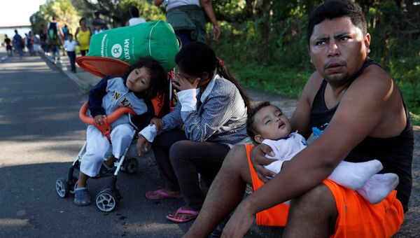 Семья в составе каравана мигрантов, идущего в США, отдыхает на своем пути в Мексике. 30 октября 2018
