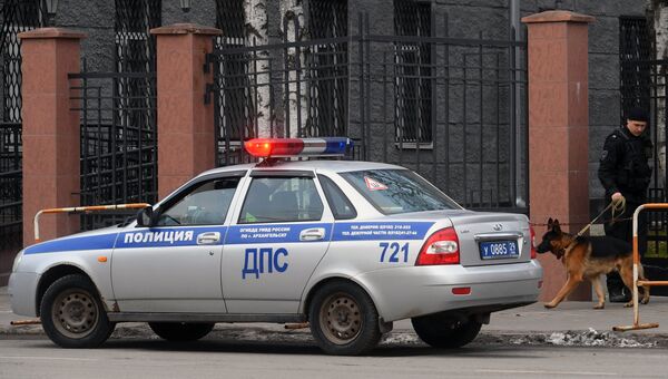 Сотрудник полиции с собакой у входа в здание управления ФСБ по Архангельской области, где произошел взрыв