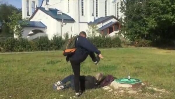 Стоп-кадр видео избиения бездомного возле храма