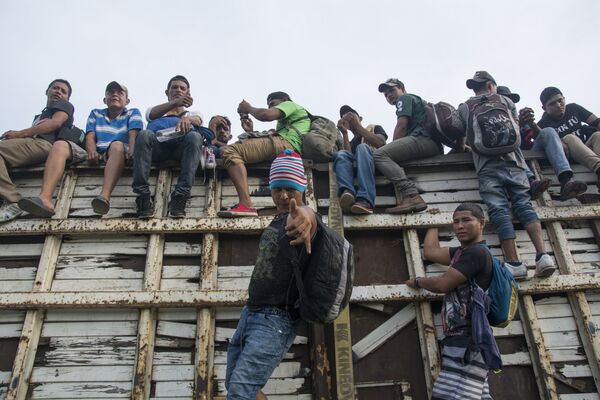 Мигранты из Гондураса, направляющиеся, в составе каравана, по территории Мексики в направлении границы с США
