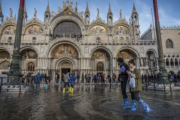 Люди на затопленной площади Святого Марка