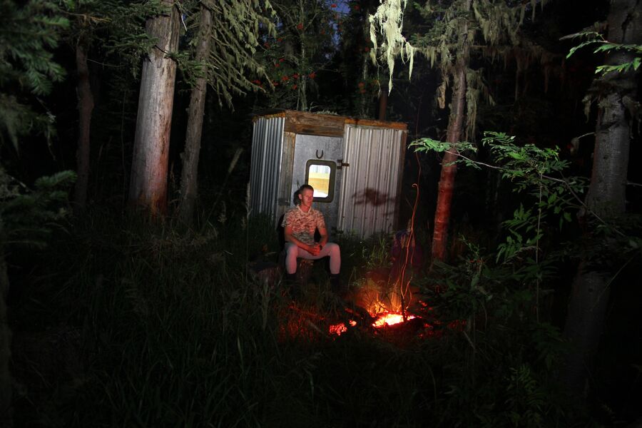 Андрей Абвгат в тайге ночью у железной избы