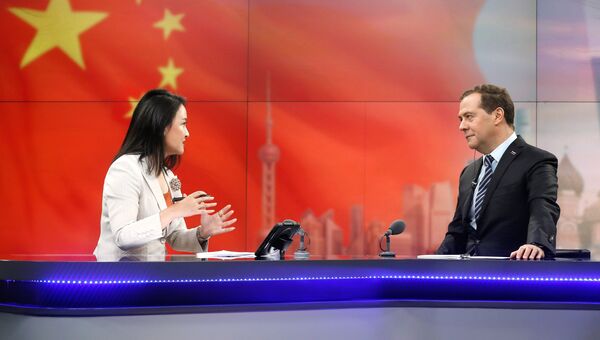 Дмитрий Медведев и ведущая Юань Мин  во время он-лайн конференции в студии штаб-квартиры Шанхайской медиагруппы. 5 ноября 2018